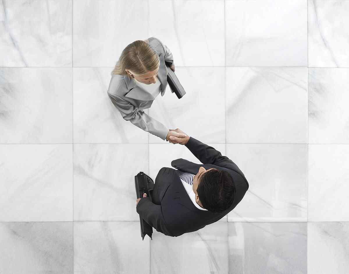 Two people shaking hands, seen from above